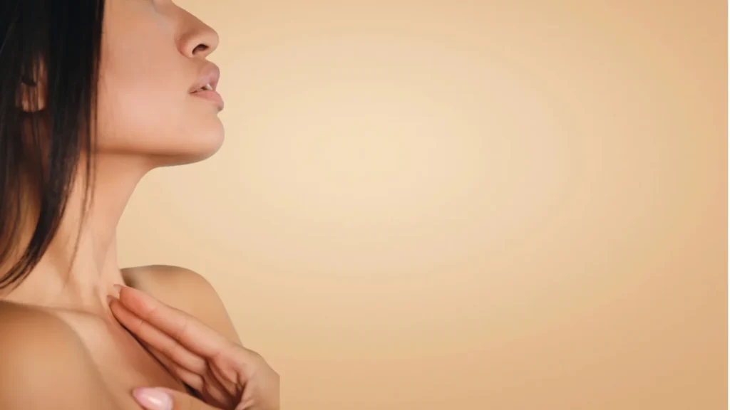 Profil kobiety z uniesioną brodą i dłonią przy dekolcie